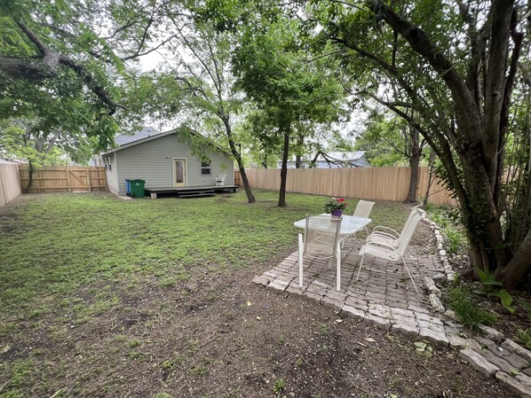 A backyard with a patio area, a small shed, and a wooden fence. - Farmhouse !! 1 min to Randy’s Icehouse, Tx Beer Co & Taylor Liquor & 5 Samsung (Taylor)