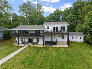 A two-story house with a covered patio, a small attached garage, and a well-maintained lawn. - Lake Norman Waterfront with Dock, hot tub fire pit and pool table (Denver)