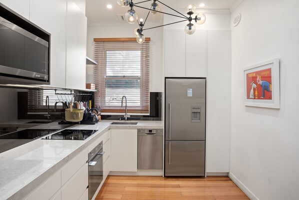 A modern kitchen with stainless steel appliances, a built-in oven, and a dishwasher.