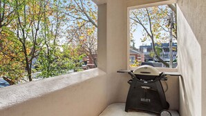 Un balcon donnant sur les arbres aux couleurs automnales et les bâtiments.