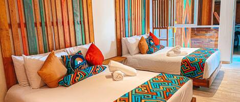 Habitación de hotel con dos camas, ropa de cama colorida y un panel de pared de listones de madera.