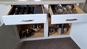 Cuina amb dos calaixos que contenen diferents utensilis i menjar cuinat.