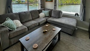 A living room with a sectional sofa, a coffee table, and a ceiling fan.
