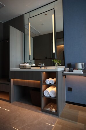 A modern bathroom with a large mirror, a sink, and a towel rack. - J.SKY HOTEL (Wuhan)