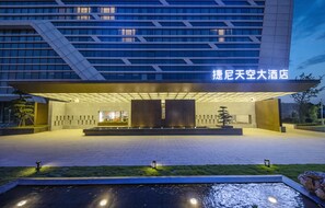 A modern hotel entrance with a large canopy and a water feature in front. - J.SKY HOTEL (Wuhan)