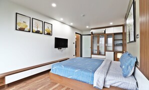 Une chambre à coucher avec un lit, une télévision et une armoire.