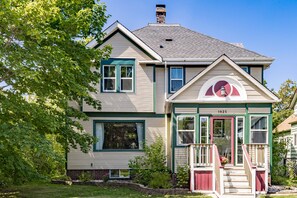 A two-story house with a front porch, a chimney, and a number '1925' on the front door. - Leraan House. Historic home in Duluth/Superior (Superior)