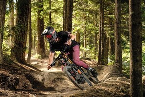 Ein Mountainbiker fährt auf einem Waldweg.