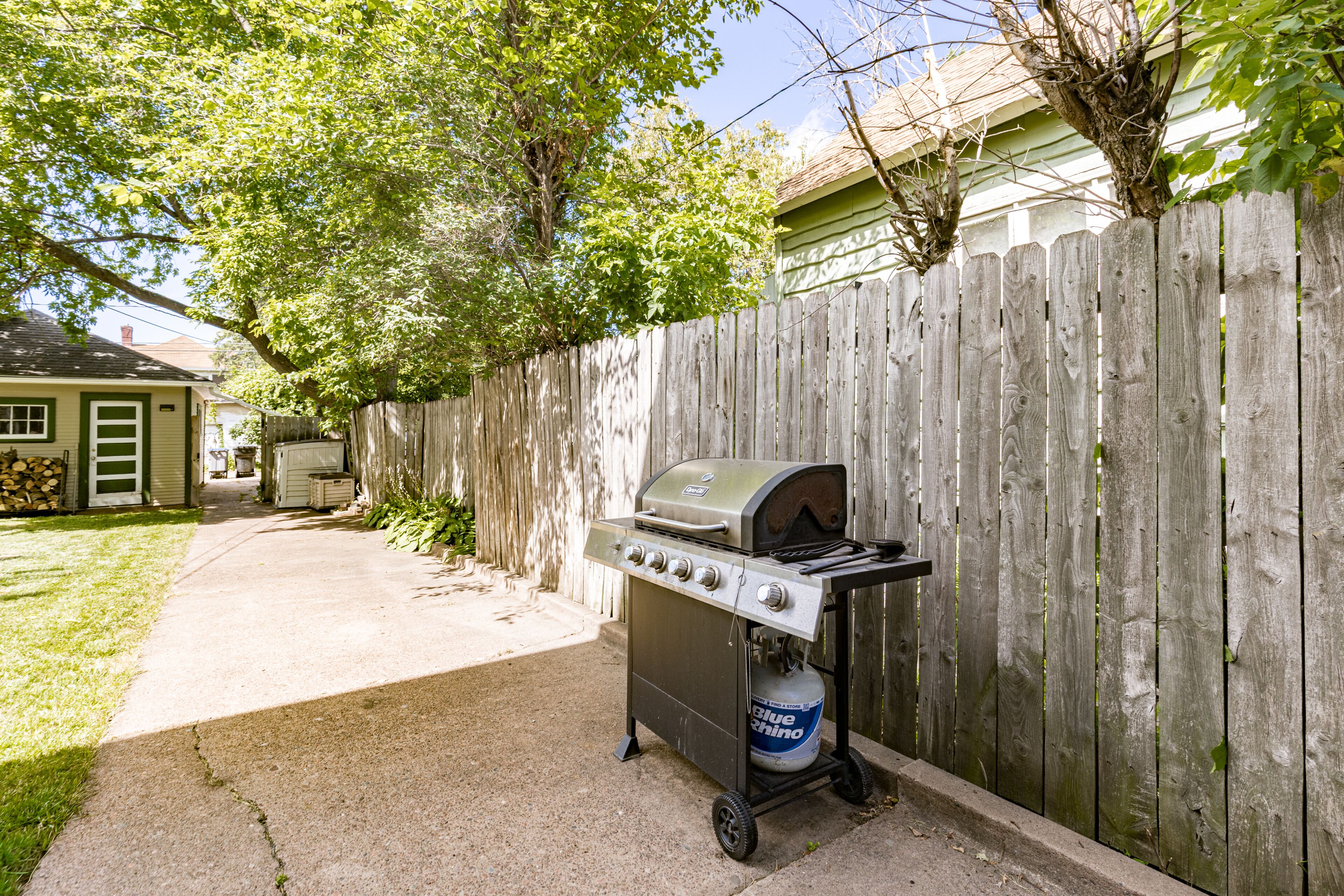 Patio con una parrilla de gas portátil y tanque de propano.