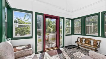 A sunroom with a bench, a door, and patterned flooring.