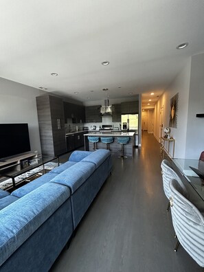 Relax in a spacious living area with a comfortable sofa, glass-top coffee table, and dining space.