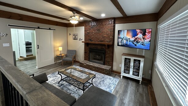 A spacious living room with a fireplace, a television, and a cozy seating area.