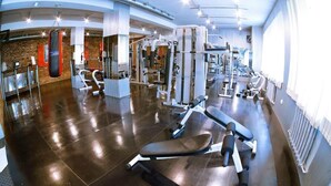 A gym with various exercise equipment, a punching bag, and a bench. - Reikartz Karaganda (Karagandy)