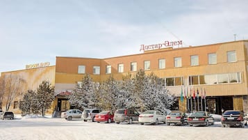 A building with a sign reading 'BOWLING' and another sign in a different language. There are several cars parked in front.