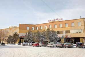 A building with a sign reading 'BOWLING' and another sign in a different language. There are several cars parked in front.