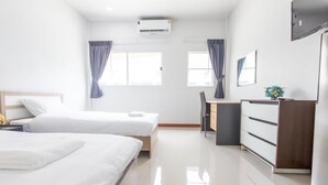 A modern hotel room with two beds, a desk, a dresser, and a flat-screen TV. - Tonsoi Hathairat (Bangkok)