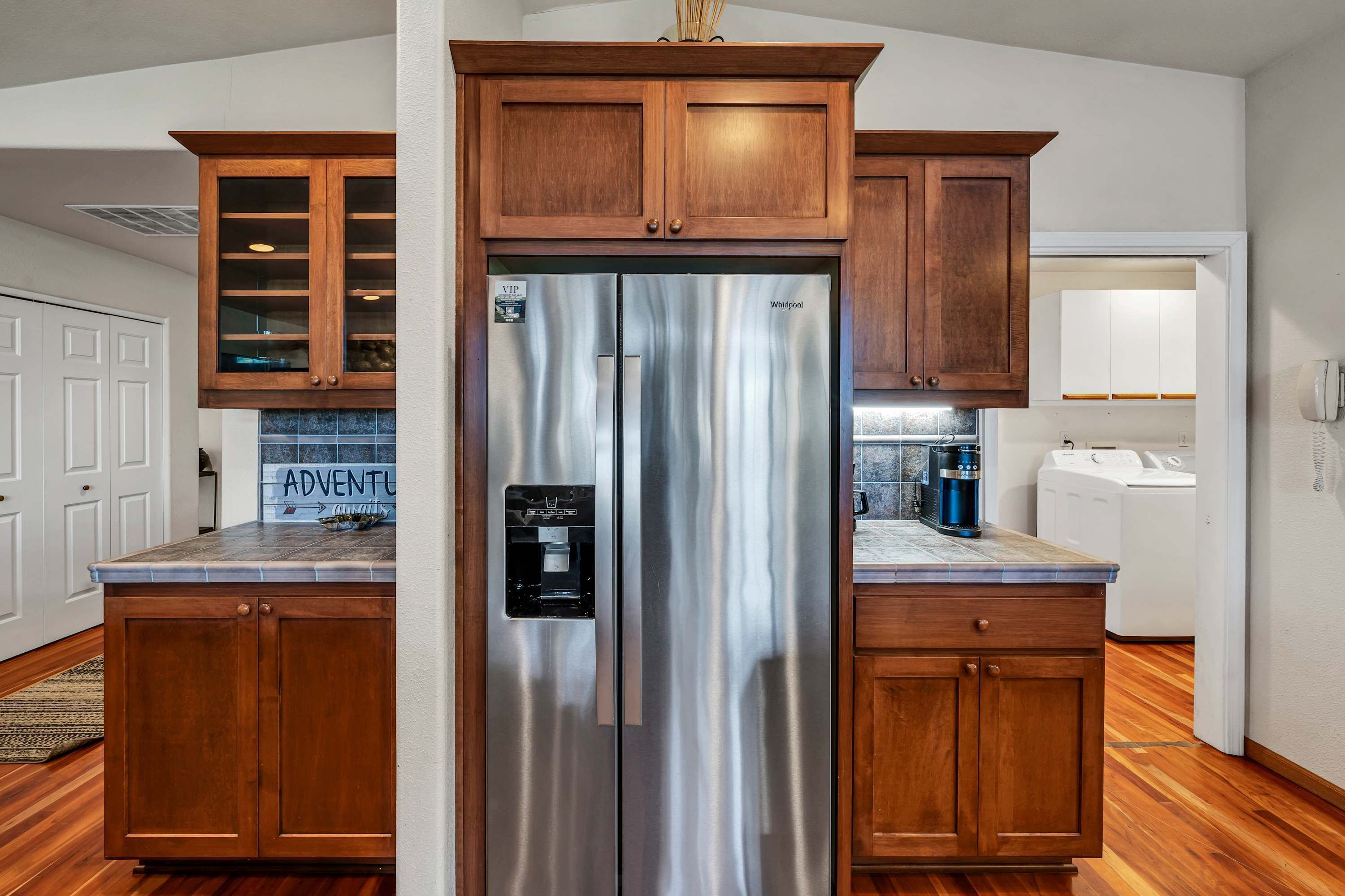 A kitchen with wooden cabinets, a stainless steel refrigerator, and a coffee maker.