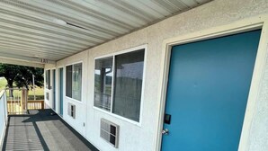 A covered corridor with a blue door, windows, and a ventilation unit. - Stand Rock Studios in Wisconsin Dells! (Wisconsin Dells)