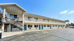 Un motel composé d’un bâtiment à deux étages, doté d’une entrée couverte et d’un parking.