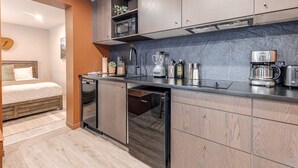 Eine kompakte Küche mit Geschirrspüler, Mikrowelle, Kaffeemaschine und Mixer.