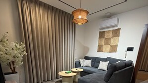 Ein modernes Wohnzimmer mit einem grauen Sofa, einem Holztisch und einem schwarz-weißen Fußboden.