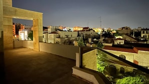 Ein Nachtblick auf ein Wohngebiet mit Gebäuden und einem Balkon mit Glasgeländer.