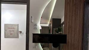 A modern interior with a curved wall, a fire hose reel, and a wooden panel. - JRE Modern Apartment In Abdoun-amman (Amman)