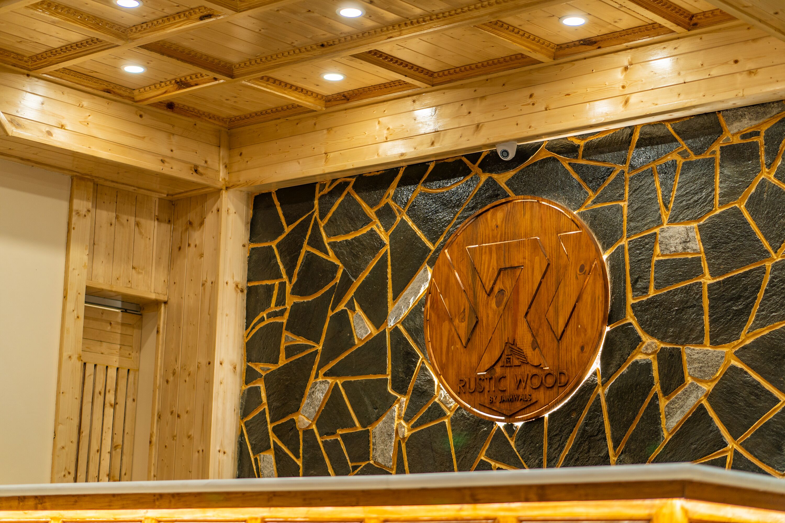 A wooden interior with a stone mosaic wall and a wooden sign reading "Rustic Wood."