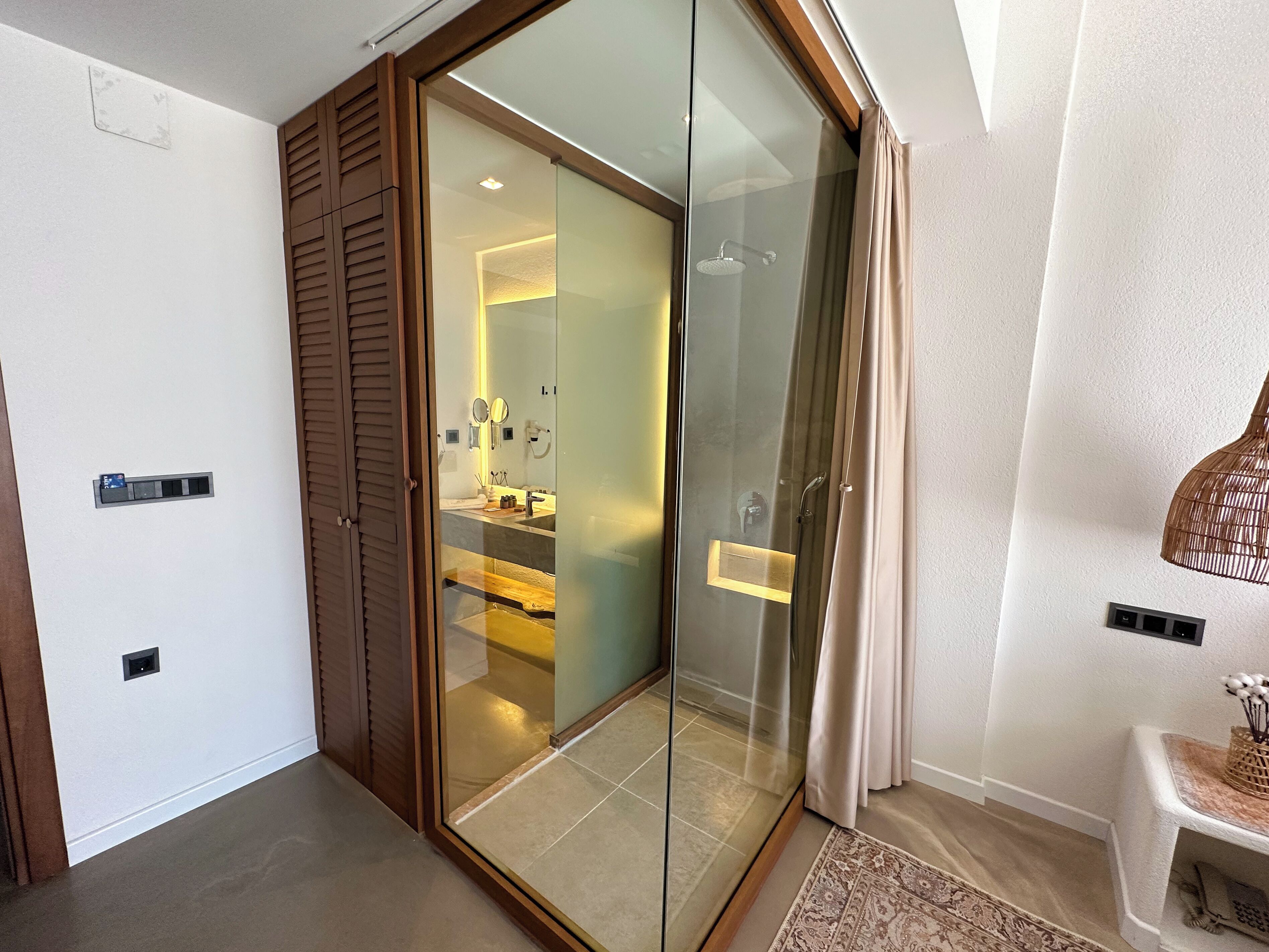 Une salle de bain moderne avec une douche à parois de verre, un meuble-lavabo avec un miroir et un porte-serviettes.