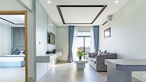 Un salon moderne avec un canapé, une table basse et un téléviseur fixé au mur.