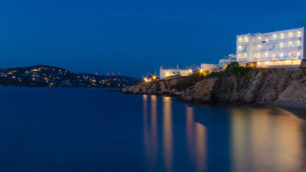 A coastal hotel with multiple floors, situated on a rocky cliff overlooking the sea. - Nikolas Hotel (Paros)