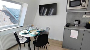 Une cuisine moderne équipée d’une table à manger pour quatre personnes, d’un four à micro-ondes et d’une bouilloire.