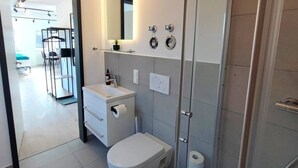Une salle de bain moderne équipée de toilettes, d’un lavabo et d’une douche.