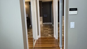 Un couloir doté d’un plancher en bois, de moulures blanches et d’un luminaire au plafond.