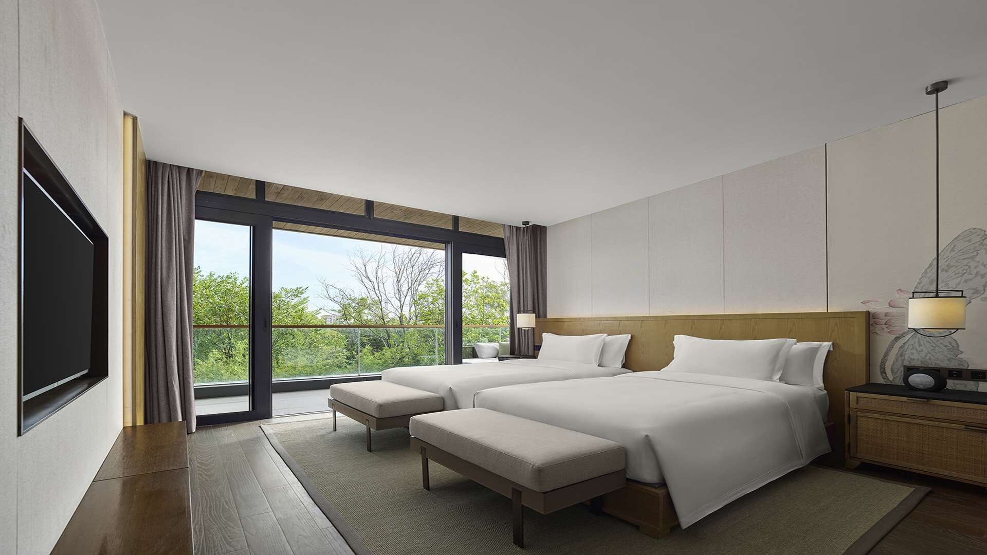 A modern hotel room with a large bed, a TV, and a view of the outdoors.