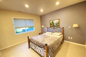 Cozy retreat with a single bed, painting, and two lamps.