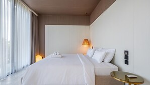 A modern hotel room with a large bed, a bedside table, and a window with curtains. - Green Flow Villa 2 with Private Pool in Ubud (Ubud)