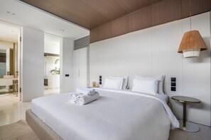 A modern hotel room with a large bed, a bedside table, a hanging lamp, and a view into the bathroom. - Amazing 2BR Green Flow Villa with Pool in Ubud (Ubud)