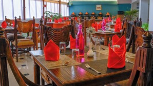 Un restaurante con muebles de madera, servilletas rojas y una pared azul.