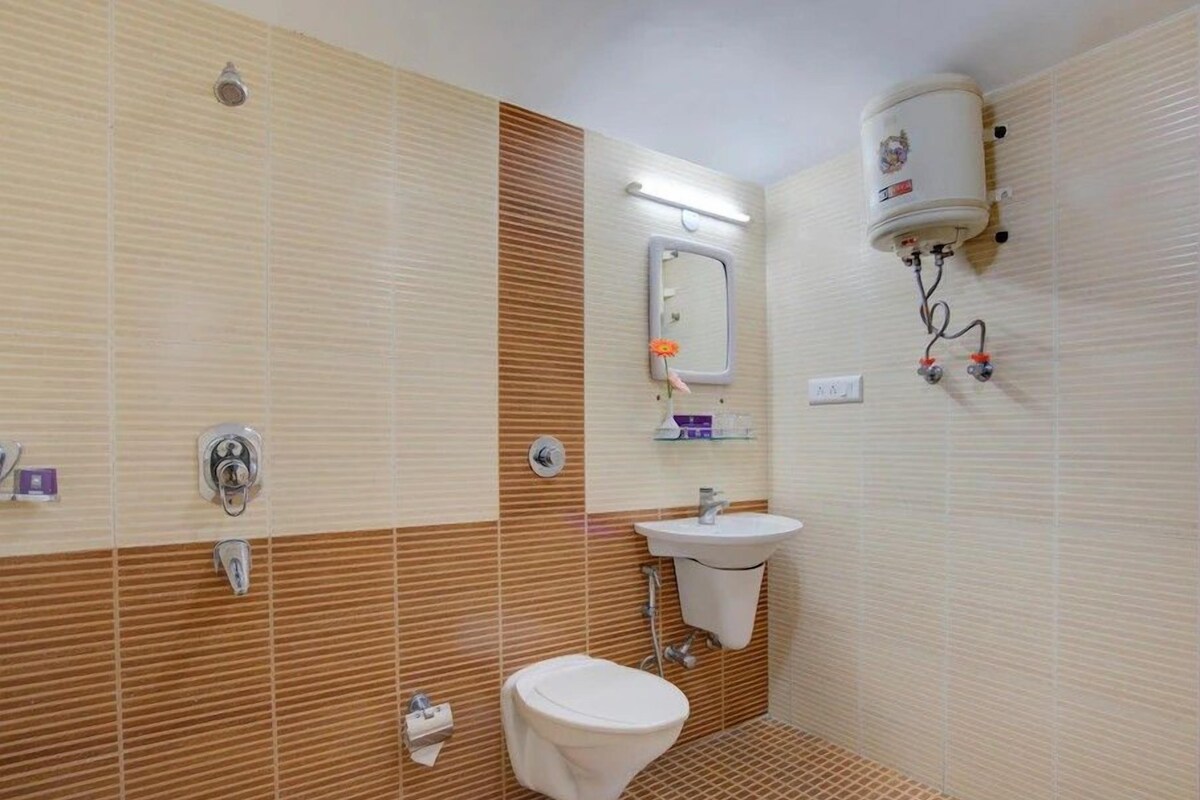 Et badeværelse med toilet, håndvask og bruser.