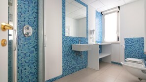 A bathroom with blue mosaic tiles, a white sink, a mirror, and a toilet. - Residenza Excelsior 808 (Vasto)