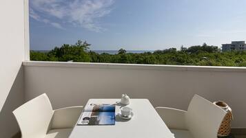 Enjoy a romantic breakfast on the balcony with a view of the lush green landscape and the sea.