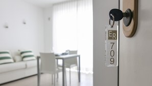 Una habitación con una puerta que indica “ER 709” y un sofá blanco con cojines a rayas al fondo.