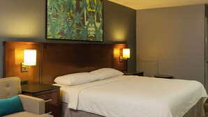 A hotel room with a bed, bedside tables, a chair, and a wall-mounted artwork. - Courtland Inn By Townhouse Franklin VA US 58 (Courtland)