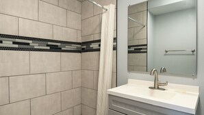 A modern bathroom with a shower, a sink, and a mirror. - Courtland Inn By Townhouse Franklin VA US 58 (Courtland)