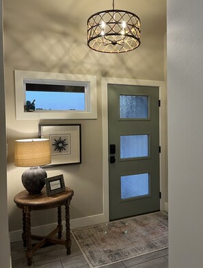 Enter a stylish space with a welcoming atmosphere, featuring a decorative light fixture, a window with an outdoor view, and a cozy reading nook.