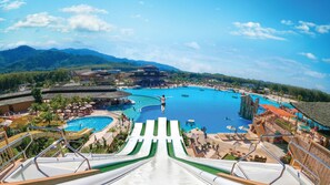 A resort with multiple swimming pools, a large water slide, and a mountainous backdrop. - The Phana (Si Sunthon)