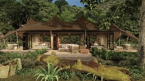 A luxurious outdoor pavilion with a bed, seating area, and a view of the surrounding forest. - The Phana (Si Sunthon)