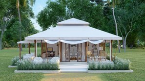 A modern pavilion with a white roof and open sides, surrounded by lush greenery and a well-maintained lawn. - The Phana (Si Sunthon)