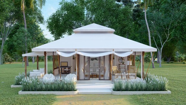 A modern pavilion with a white roof and open sides, surrounded by lush greenery and a well-maintained lawn. - The Phana (Si Sunthon)
